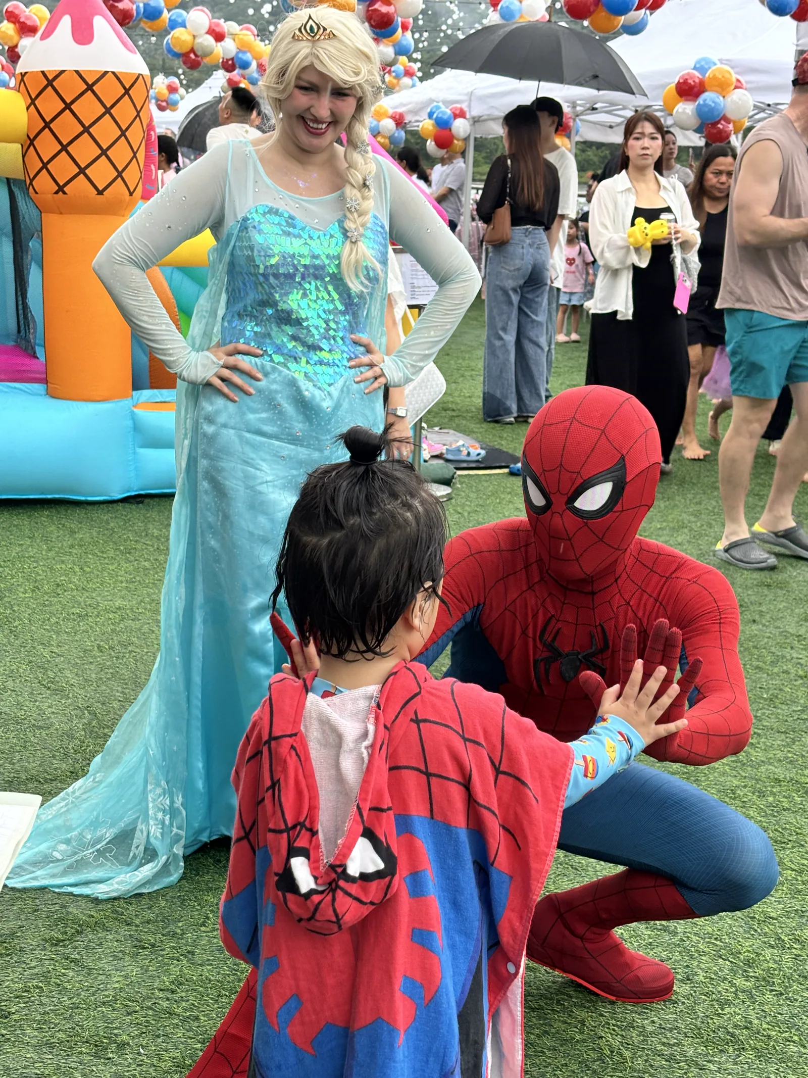 Spider-Man and Elsa interacting with a child at a Hong Kong birthday party